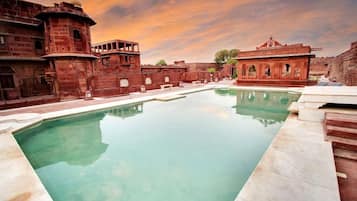 A pool surrounded by traditional architecture with a clear sky.