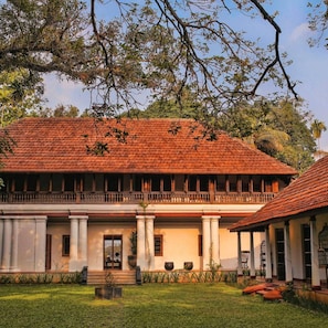 A traditional building with a tiled roof, columns, and a balcony.