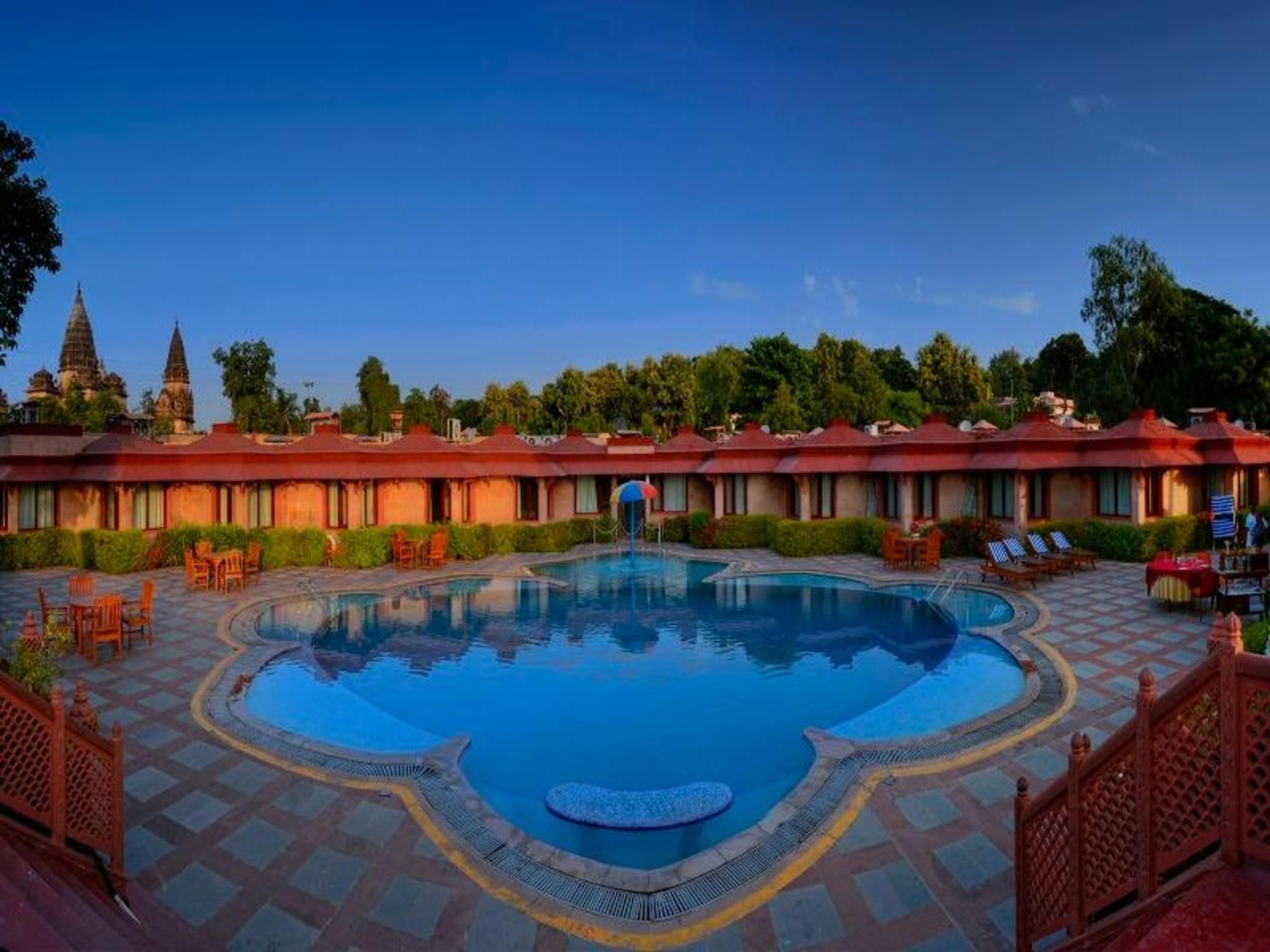 Un hotel con piscina, mobiliario exterior y arquitectura tradicional.