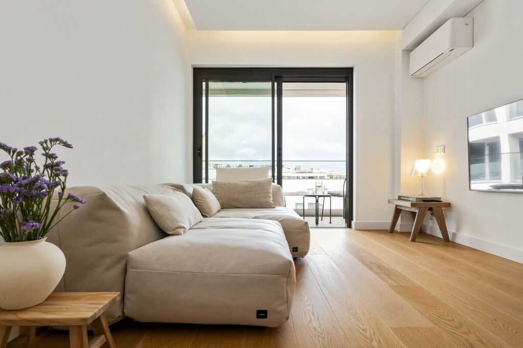 Una sala moderna con un sofá, una mesita y una planta en maceta.