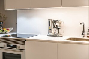 A modern kitchen with a built-in oven, a coffee machine, and a stainless steel sink. - Holiday apartment with 2 bedrooms (Funchal)