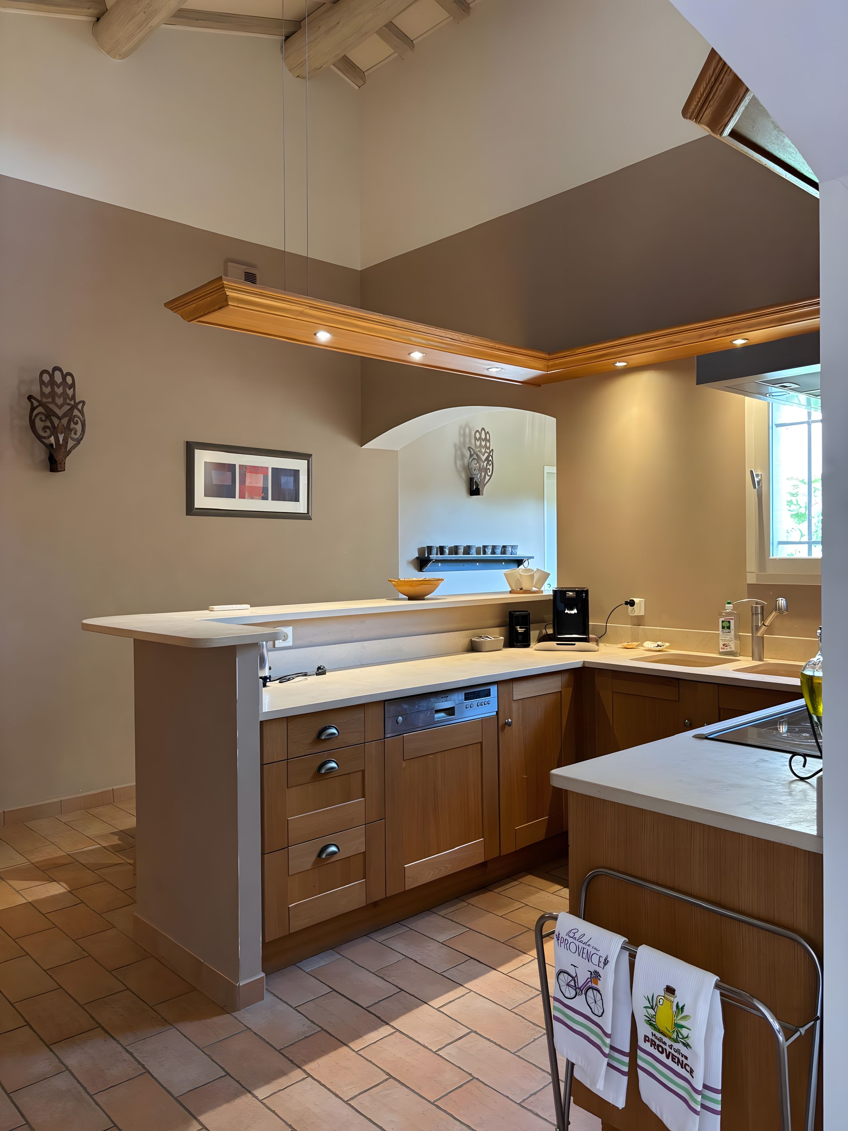 A modern kitchen with a central island, wooden cabinets, and a built-in oven.
