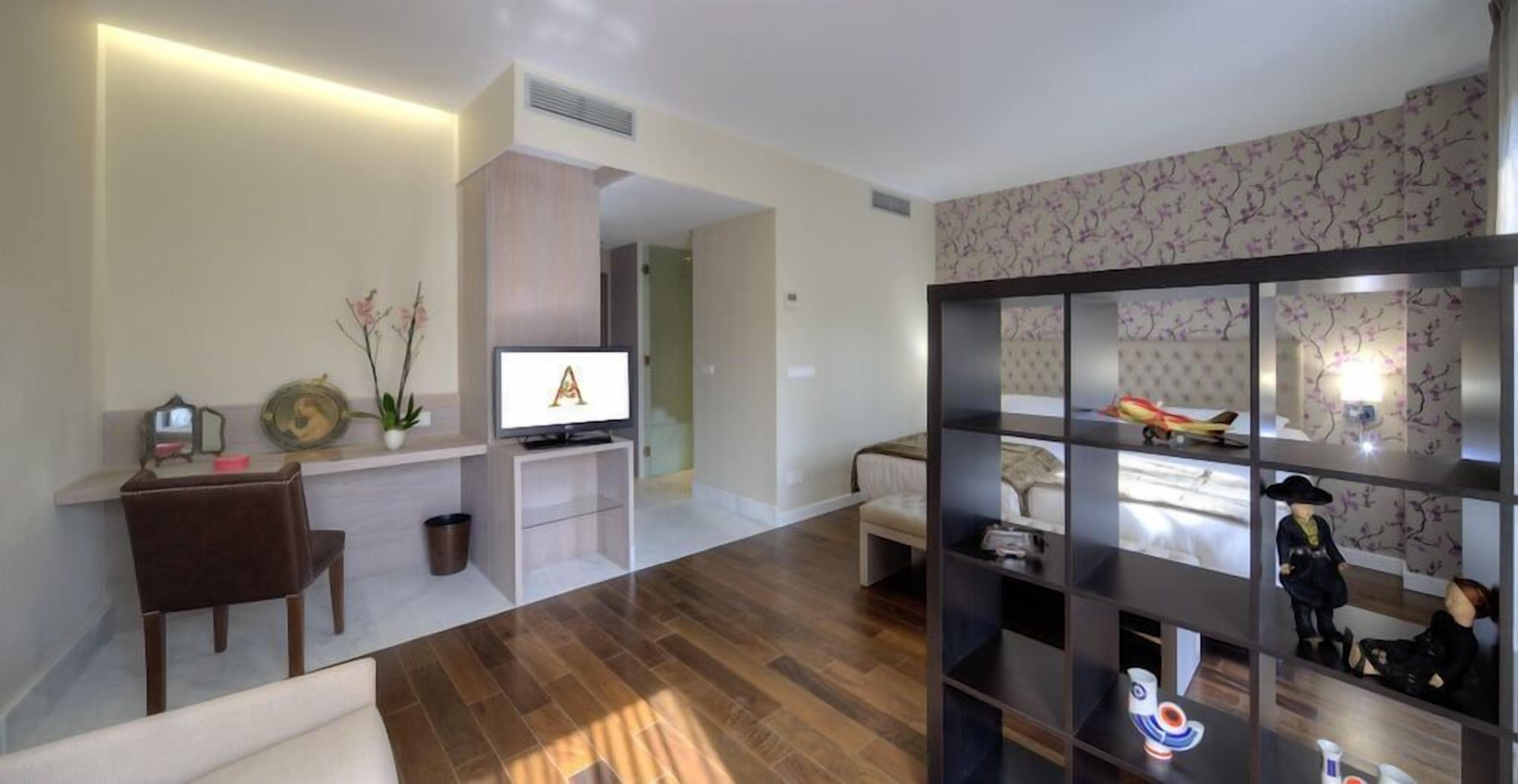 Una sala de estar moderna con un televisor de pantalla plana, un sofá, una mesa de centro y una estantería.