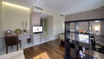 Una sala de estar moderna con un televisor de pantalla plana, un sofá, una mesa de centro y una estantería.