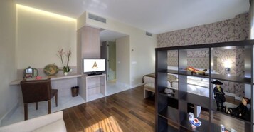 Uma sala de estar moderna com televisão de tela plana, sofá, mesa de centro e estante de livros.