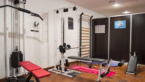 Academia com diversos equipamentos de exercício, incluindo um banco de supino, uma estrutura para agachamento e uma barra fixa.