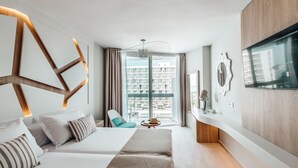 A modern hotel room with a large bed, a sofa, a small table, and a TV. - Sirenis Hotel Goleta And Spa (Ibiza Town)
