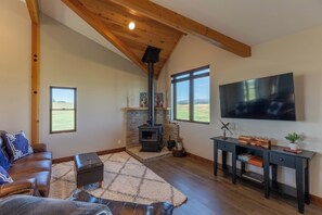 Ein gemütliches Wohnzimmer mit Kamin, Ledersofa und Flachbildfernseher.
