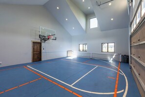 Eine Indoor-Basketballhalle mit Korb, Tür und Fenstern.
