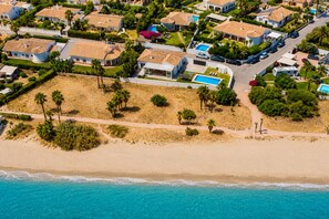 A coastal residential area with houses, a beach, and a swimming pool.