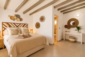 A bedroom with a wooden headboard, a bed with multiple pillows, a bedside table, and a nightstand. - « BOHO MAR » - Your next holiday beach villa in Estepona (Saladillo Benamara)