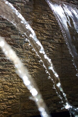 A stone wall with a water feature.