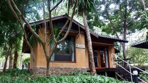A small, single-story building with a tiled roof, surrounded by lush greenery and a stone base. - Wanathara Health Resort & Spa (Wang Thong)