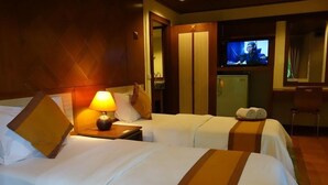 A hotel room with two beds, a television, a desk, and a chair. - Wanathara Health Resort & Spa (Wang Thong)