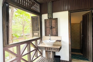 A wooden balcony with a white sink and a decorative cabinet. - Royal Ping Garden and Resort (San Sai)