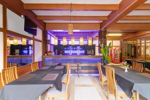 A restaurant with a bar area, wooden furniture, and a meeting room.