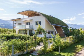 A modern house with a sloped roof, a balcony, and a garden. - "Green" on the Sandwiesen farm (Gargazon)