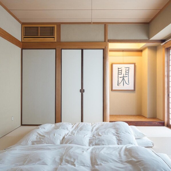 A bedroom with a bed, a wardrobe, and a framed artwork on the wall. - Tabiyu Abrigo Hotel (Kobe)