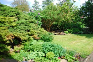 Ein gepflegter Garten mit verschiedenen Sträuchern und einer Rasenfläche.