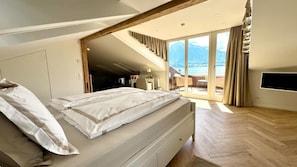 A bedroom with a bed, a desk, and a view of the outdoors. - Luzern House With Indoor Pool (Lucerne)