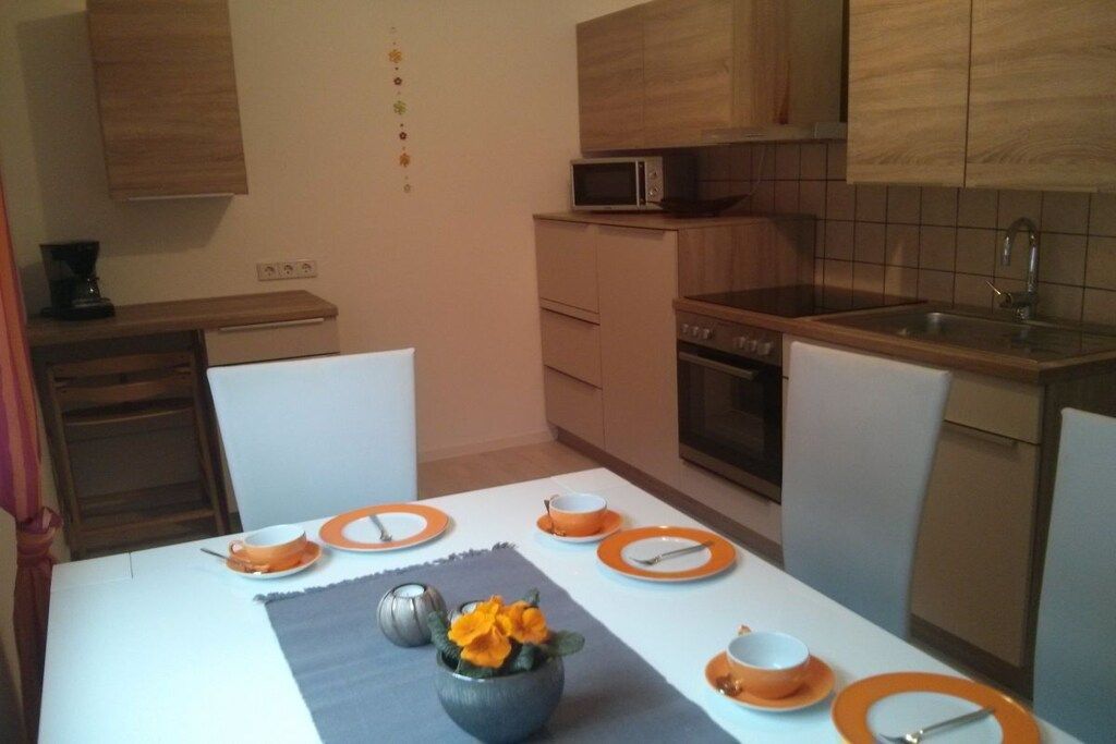 Een moderne keuken met houten kastjes, een magnetron en een spoelbak.