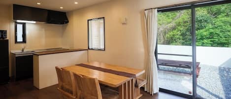Una cocina moderna con comedor, un amplio ventanal con cortinas y vistas al exterior.