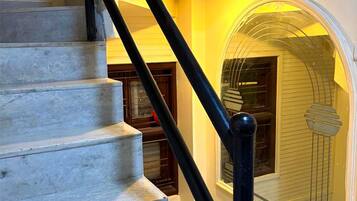 A staircase with a black handrail leading to a landing.