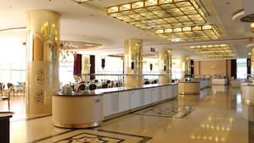 Eine großzügige Hotelhalle mit einer zentralen Rezeption, imposanten Dekorationssäulen und einem gemusterten Boden.