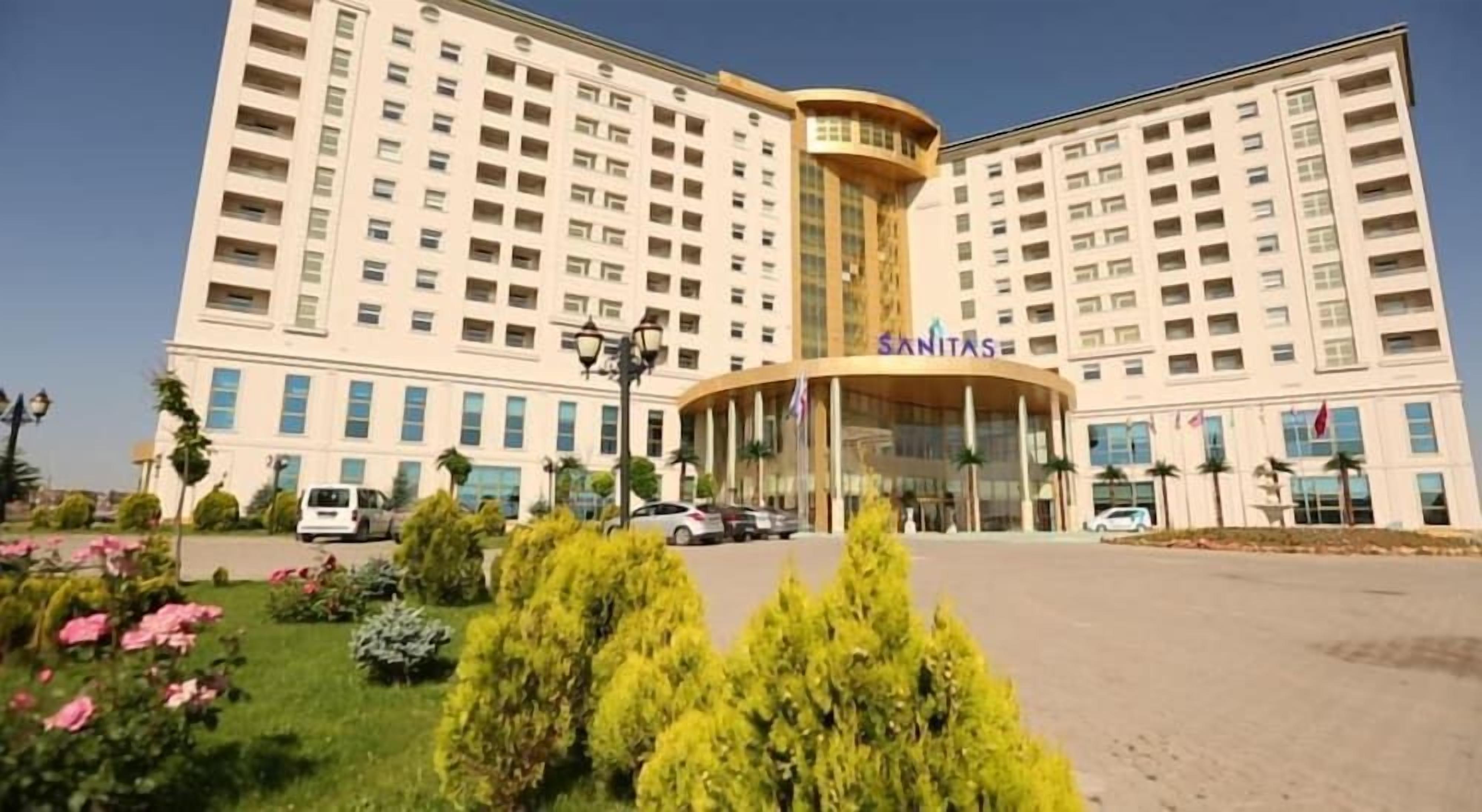 Ein großes Hotel mit einem zentralen Eingang, mehreren Stockwerken und einem gepflegten Gartenbereich.
