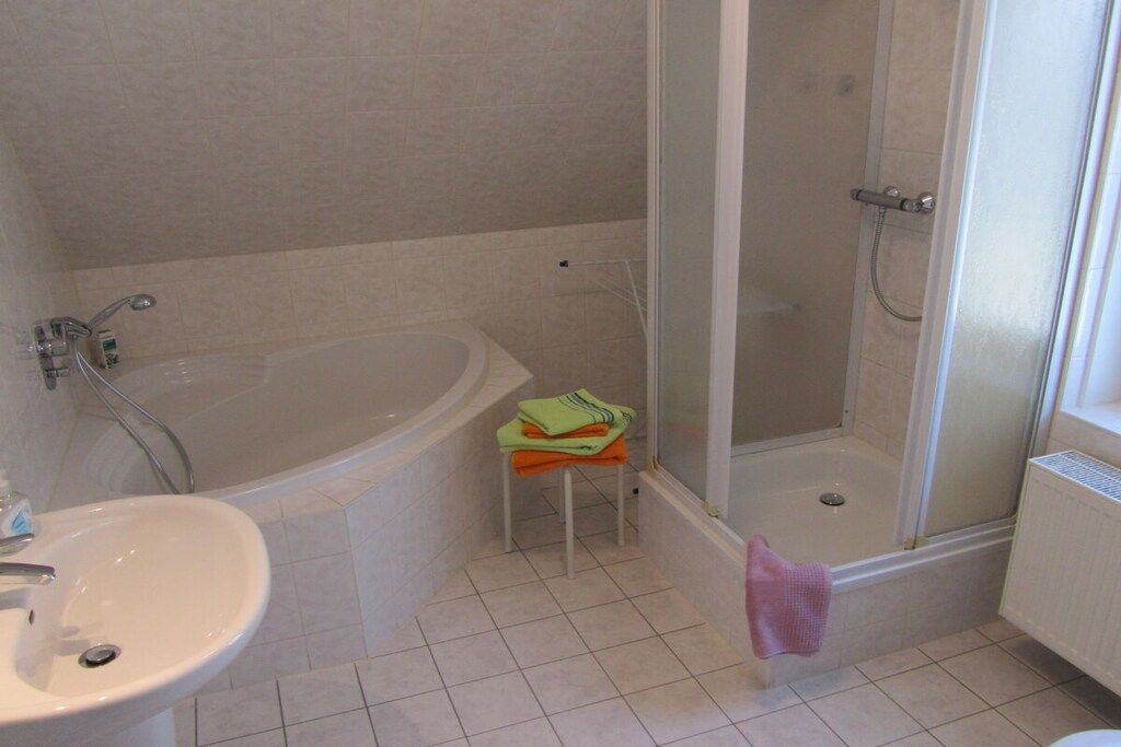 A bathroom with a bathtub, a shower, and a sink.