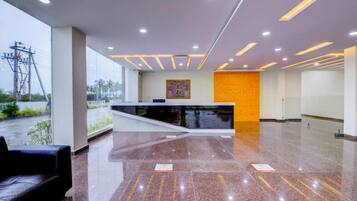 A modern reception area with a glass wall, a reception desk, and a seating area.
