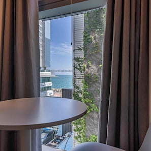 A room with a view of a bridge, a body of water, and a building across the street. - Gwangalli Gray 193 Hotel (Busan)