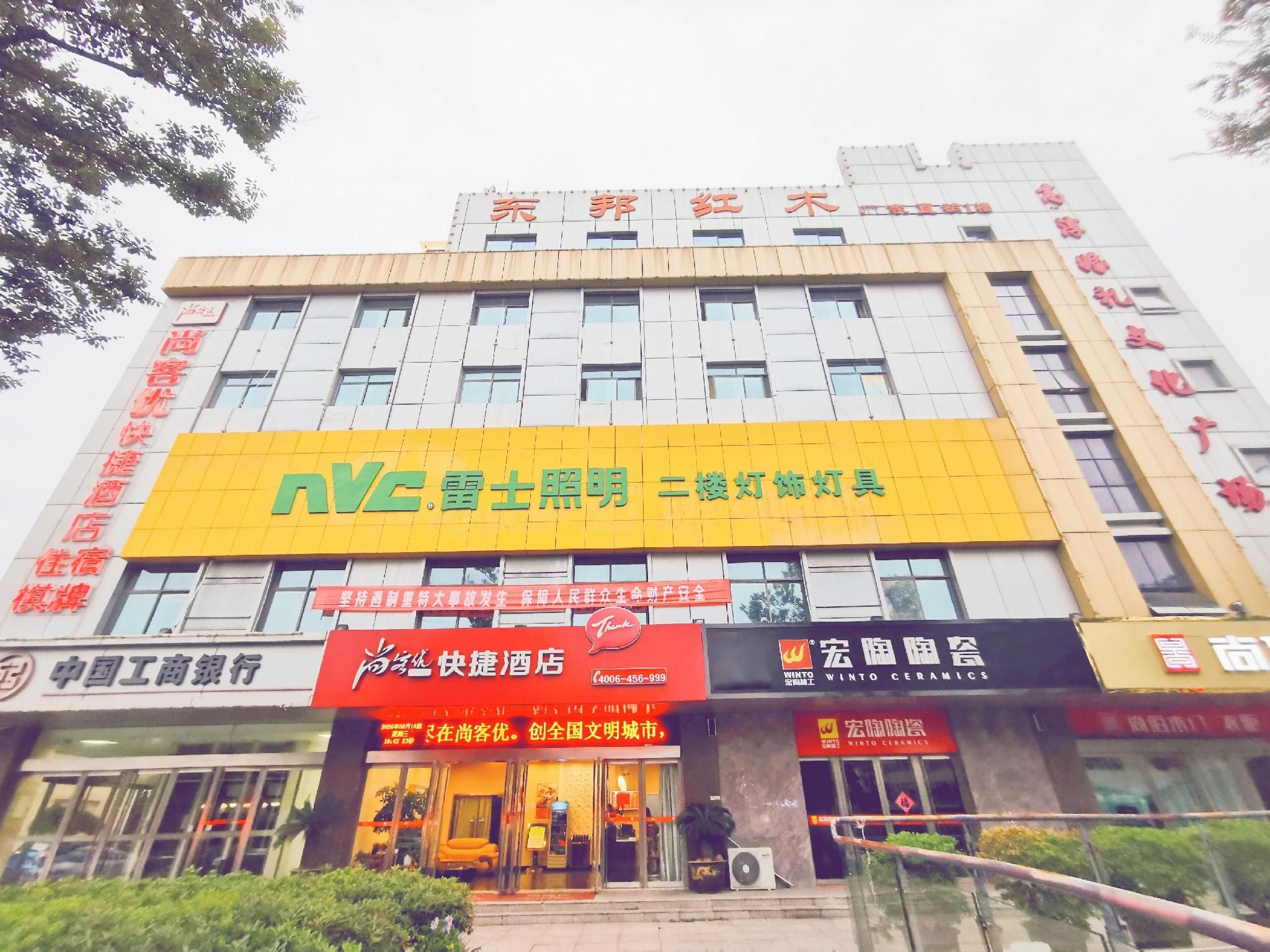 Un edificio de varios pisos con un llamativo letrero amarillo para un hotel y un restaurante.
