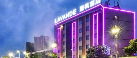 A hotel with a prominent sign, multiple floors, and a modern architectural design.
