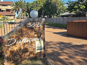 A brick wall with a metal sign displaying the number '563' and the name 'Driftwood.'