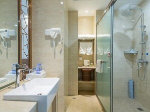 Un bany modern amb dutxa envidriada, un lavabo blanc i un mirall.