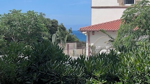 A building with a red-tiled roof, a small arched window, and a view of the sea. - Borgo Design Apartment by the sea (Civitavecchia)