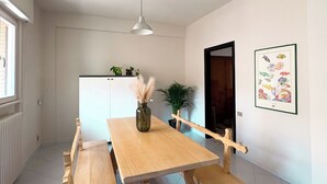 A dining area with a wooden table and benches, a ceiling fan, a window, and a door. - Borgo Design Apartment by the sea (Civitavecchia)