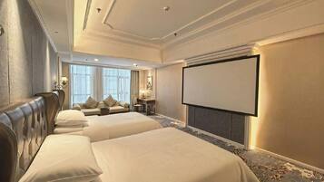A hotel room with two beds, a desk, a chair, a television, and a large window.
