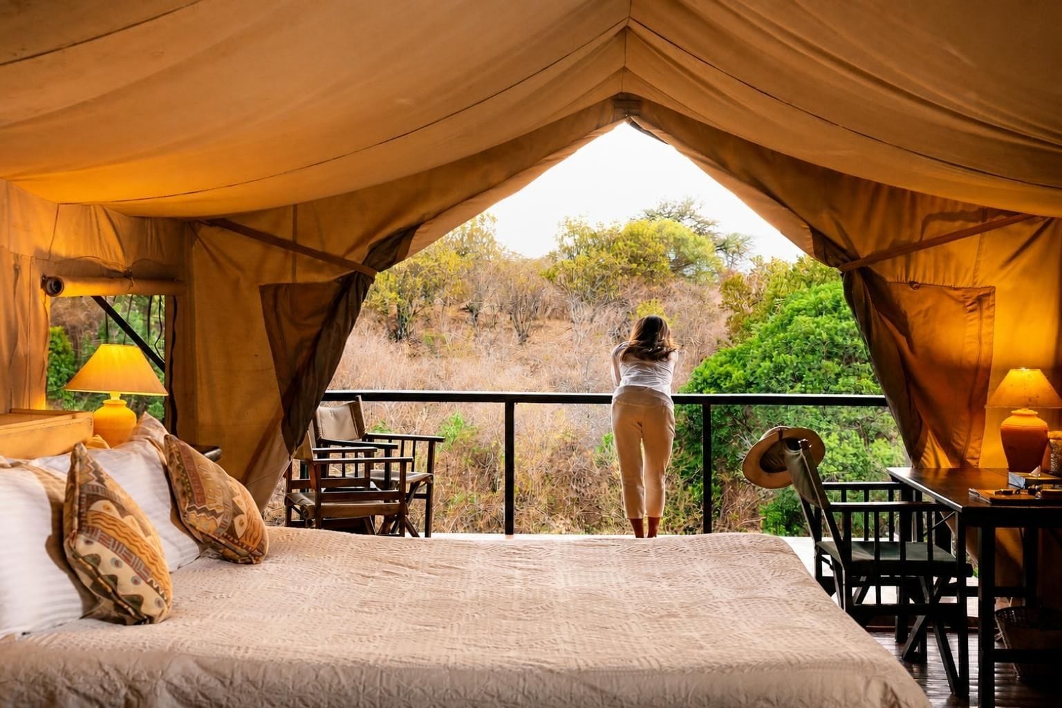 Una habitación con tienda de campaña, una cama, sillas y una mesa.