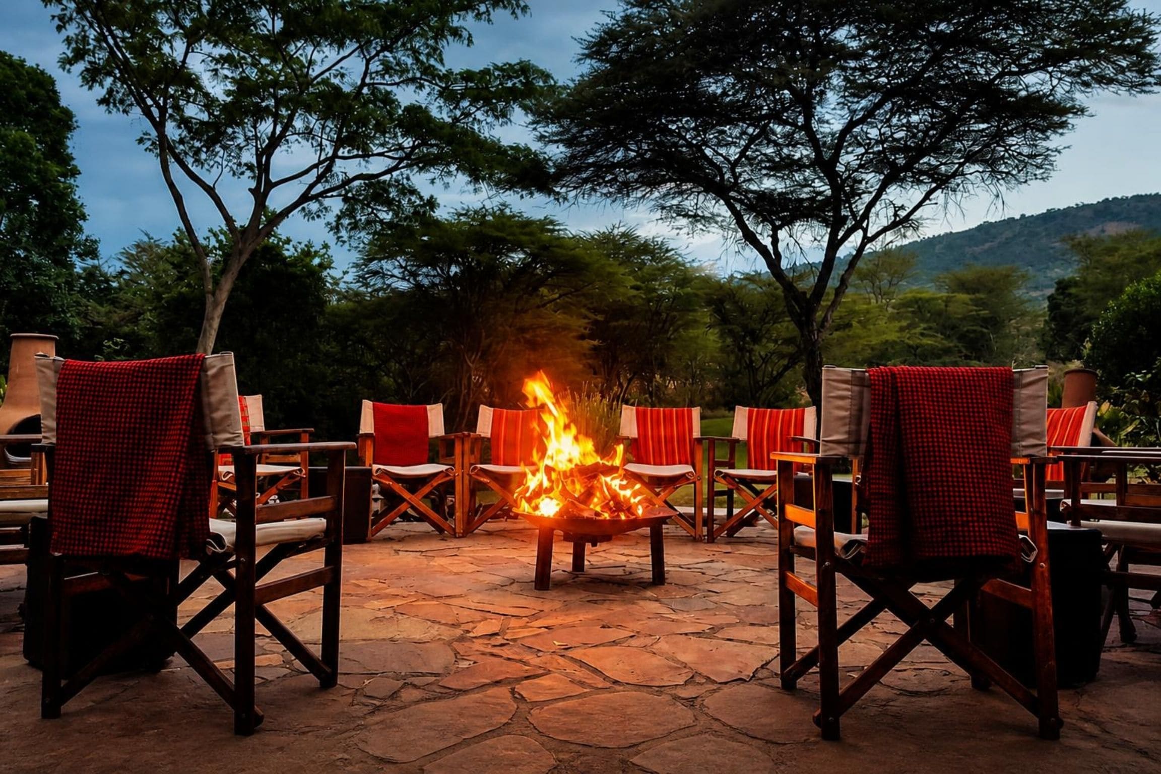An outdoor seating area with a fire pit surrounded by chairs and tables.