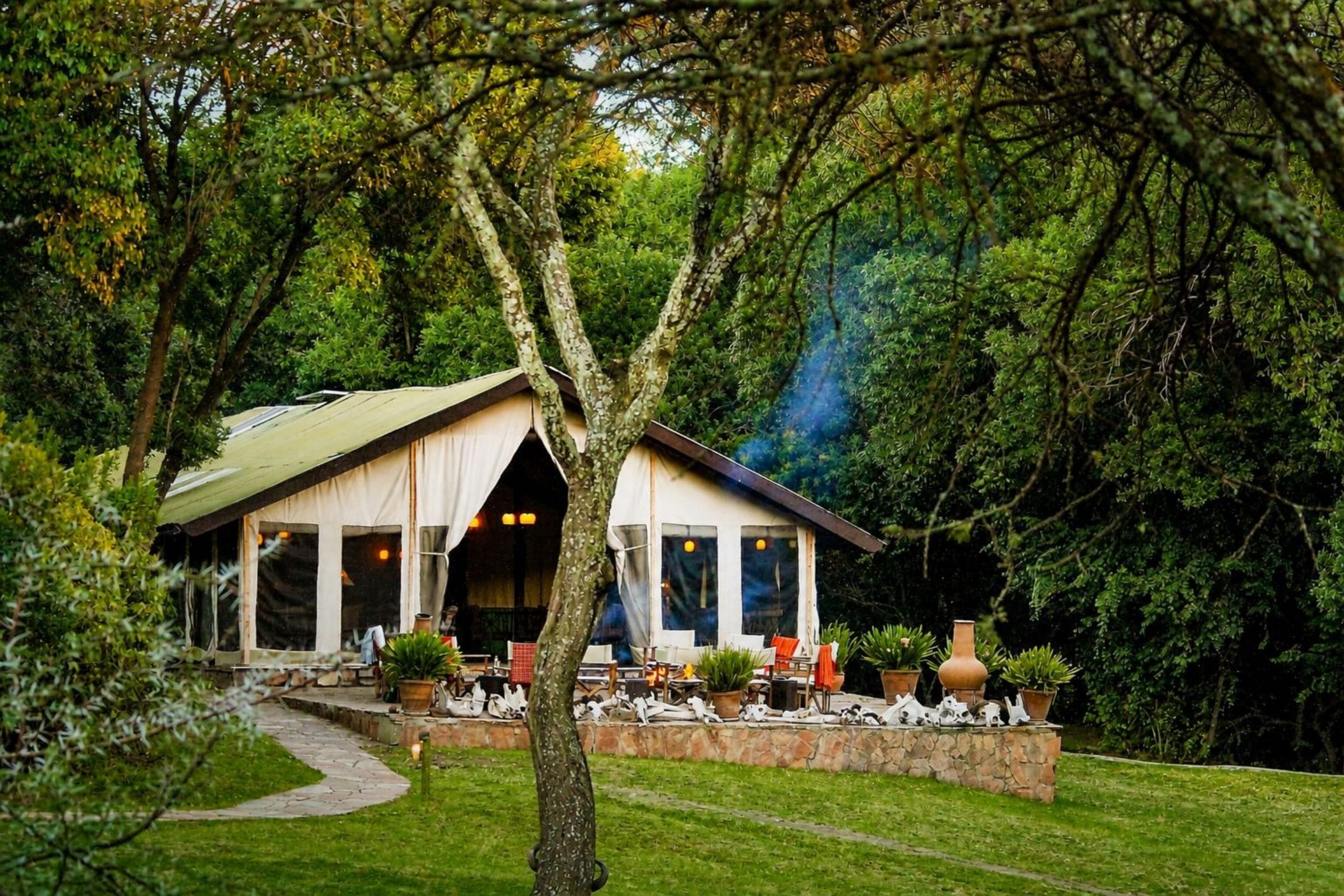 Un chalet rustique avec un sentier de pierres menant à un espace de repos abrité.