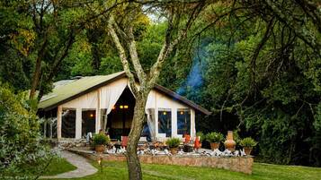 Un chalet rustique avec un sentier de pierres menant à un espace de repos abrité.