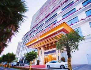 A multi-story hotel with a prominent entrance, large windows, and a red carpet leading to the entrance. - Vienna International Hotel (Sanya)