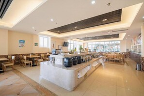 A spacious hotel lobby with a central island, seating areas, and a large window providing natural light. - Vienna International Hotel (Sanya)