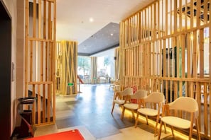 A modern interior with a wooden partition, a staircase, and seating area.