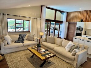 A living room with two sofas, a coffee table, and a view of the outside.