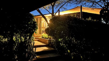Un sendero que lleva a un edificio con fachada de piedra y una puerta.