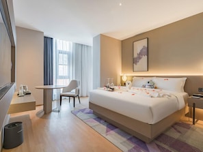 A modern hotel room with a large bed, a desk, and a chair. - Lavande Hotel (Beijing)