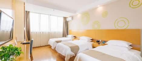 A hotel room with two beds, a desk with a television, and a window with curtains.